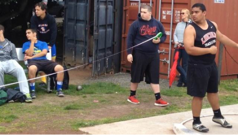 Karl watches his last throw and waits to hear the official measurement, while throwers from Aloha look on.