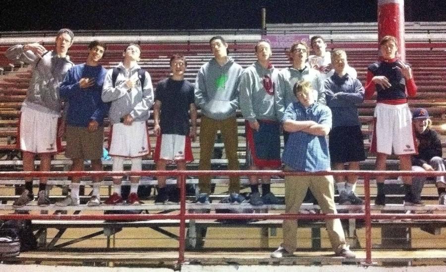 Bad weather did not stop Flock members from cheering at the last JV girls soccer match Oct. 27 at Lincoln. From left: Tim Shelton, Jonah Danziger, Will Holland, Cosimo Gaudio, Gabe Keim, Perry Elsasser, Jack Ritt, Mason Fredericks, Austin Sacker, Nolan Ostmo, Michael Angyus, and Bobby Mazzocco (front).