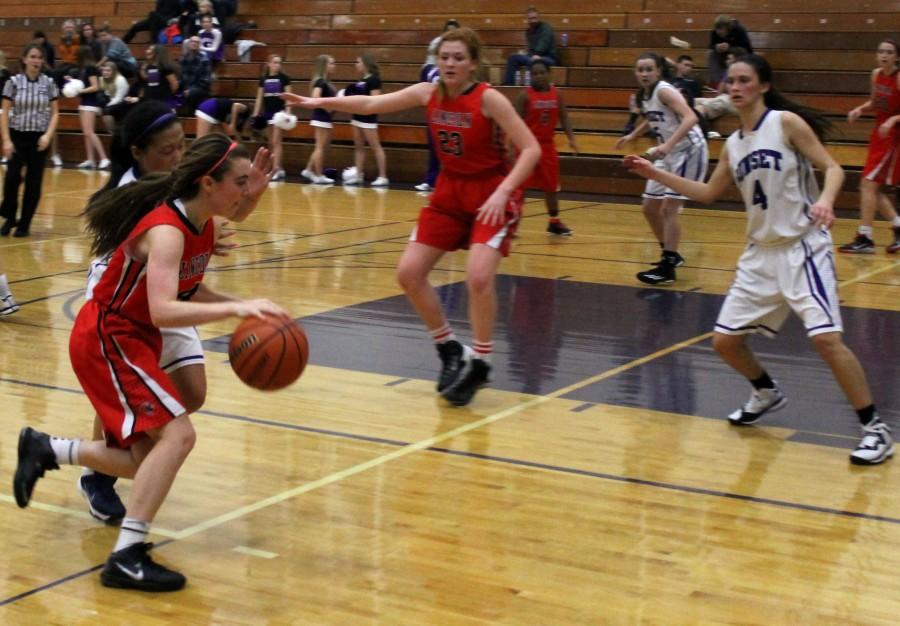 Senior guard Abby Eakin charges to the basket against a Sunset opponent as sophomore Gracie Summers moves in for support. The girls lost 67-50 but came back two days later to beat Central, from Independence, 69-45.