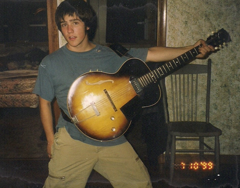Mr. Watson, at age sixteen, holds his favorite guitar. 