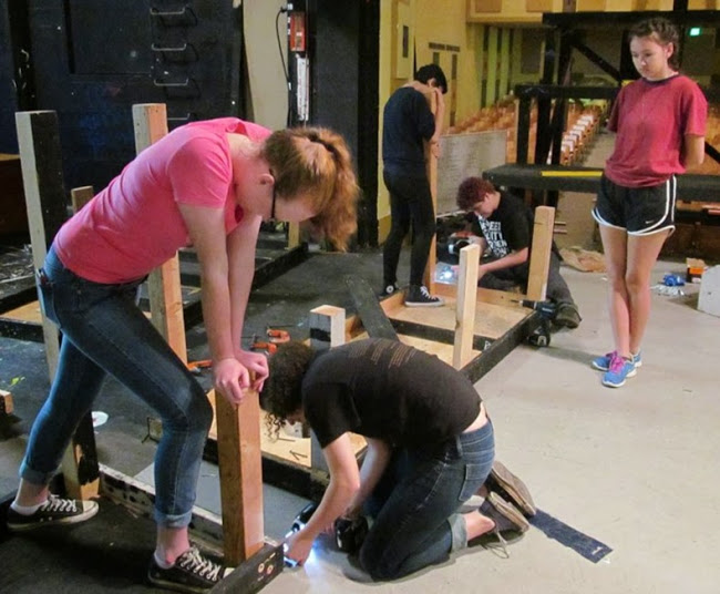 Abigail Meskimen (left) and Fran Smyth build the set for All in the Timing with help from design workshop students. 