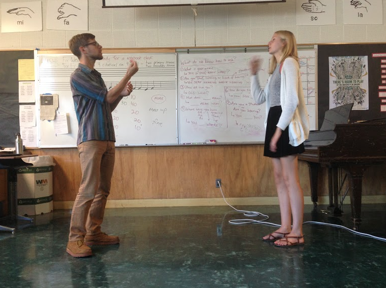 ASL teacher Ben Malbin demonstrates sign language to sophomore Julia Dodson.