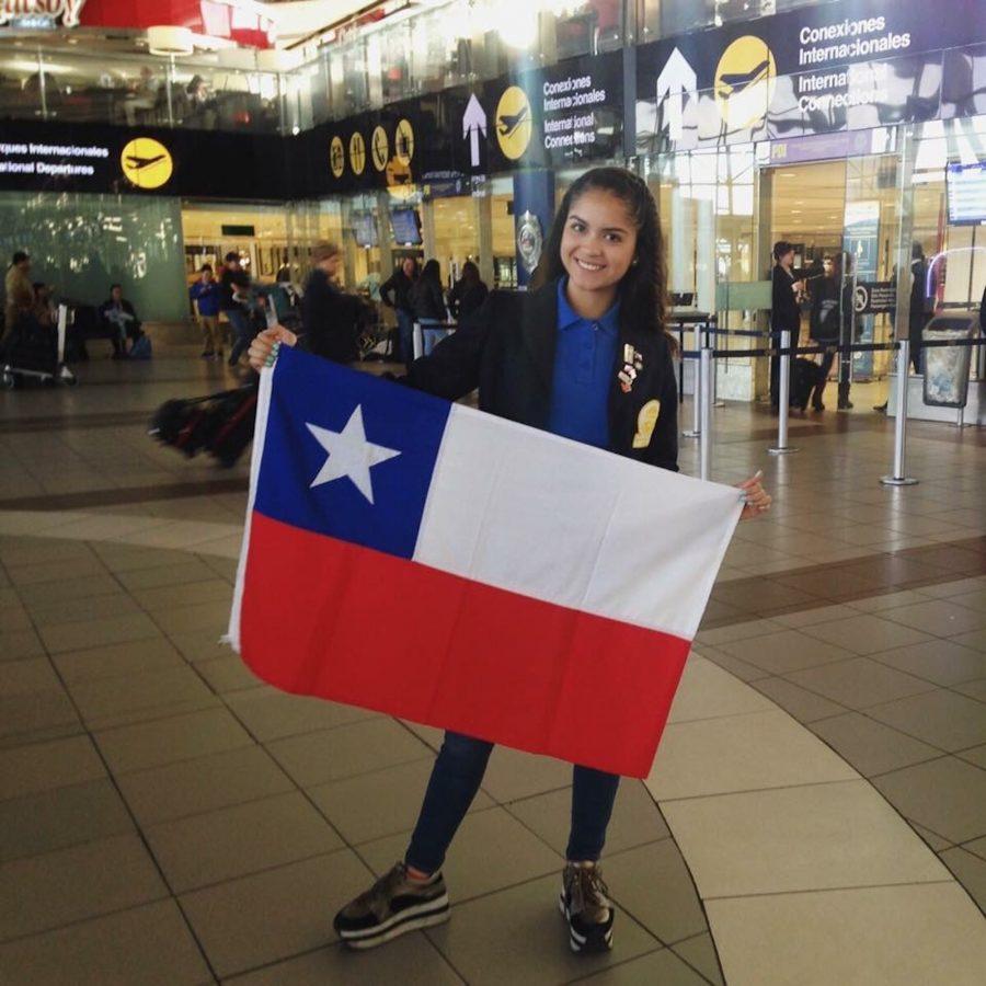 Paula Perez-Rojo at an airport holding the Chilean flag.