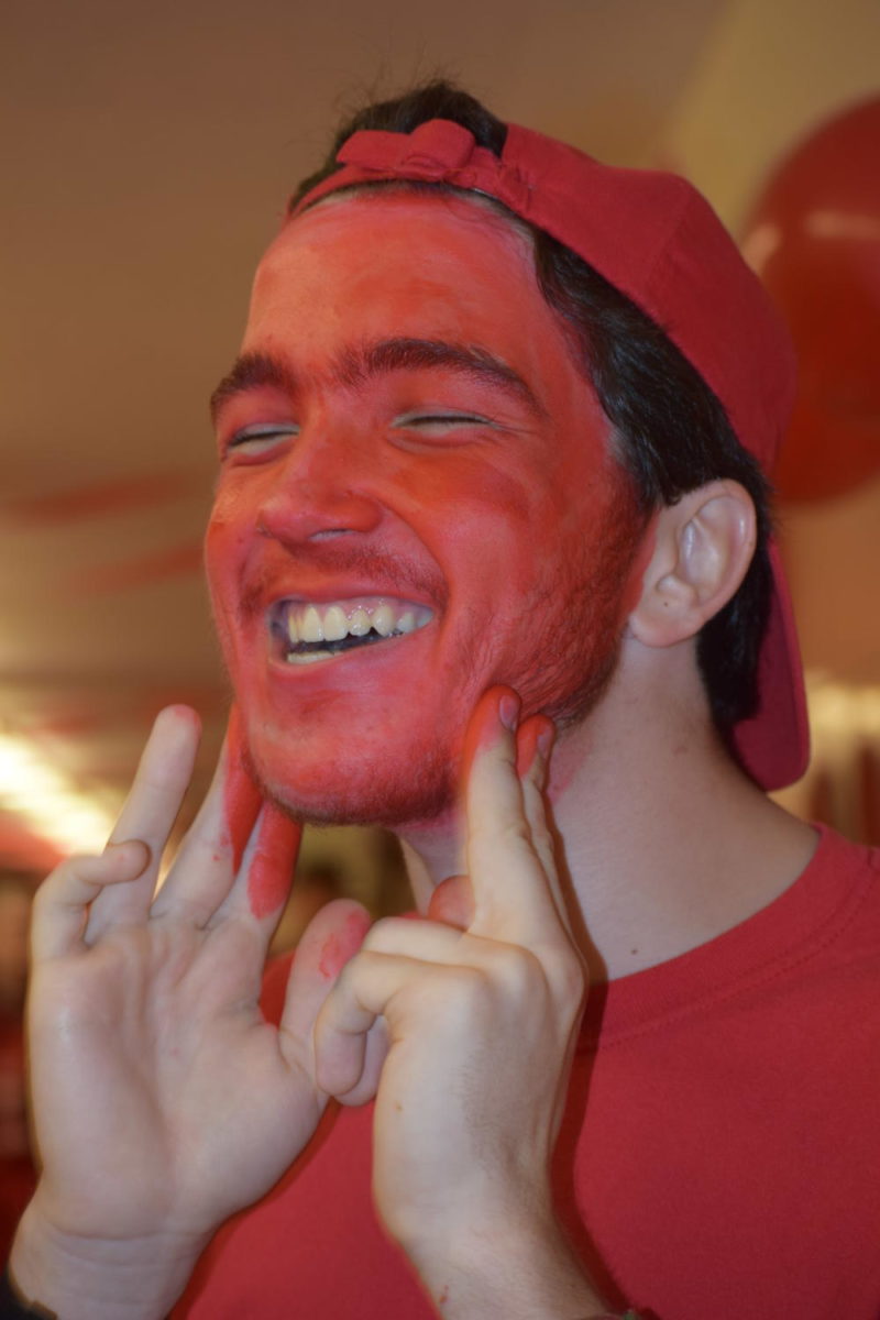 Senior Alex Sathler dons face paint before the assembly.