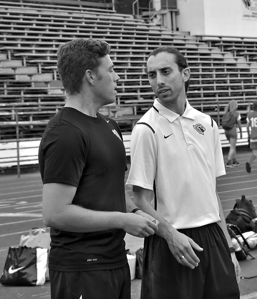 Spanish teacher Pablo Dipascuale, who has taken over as head boys soccer coach, speaks to assistance Stefan Viragh during practice