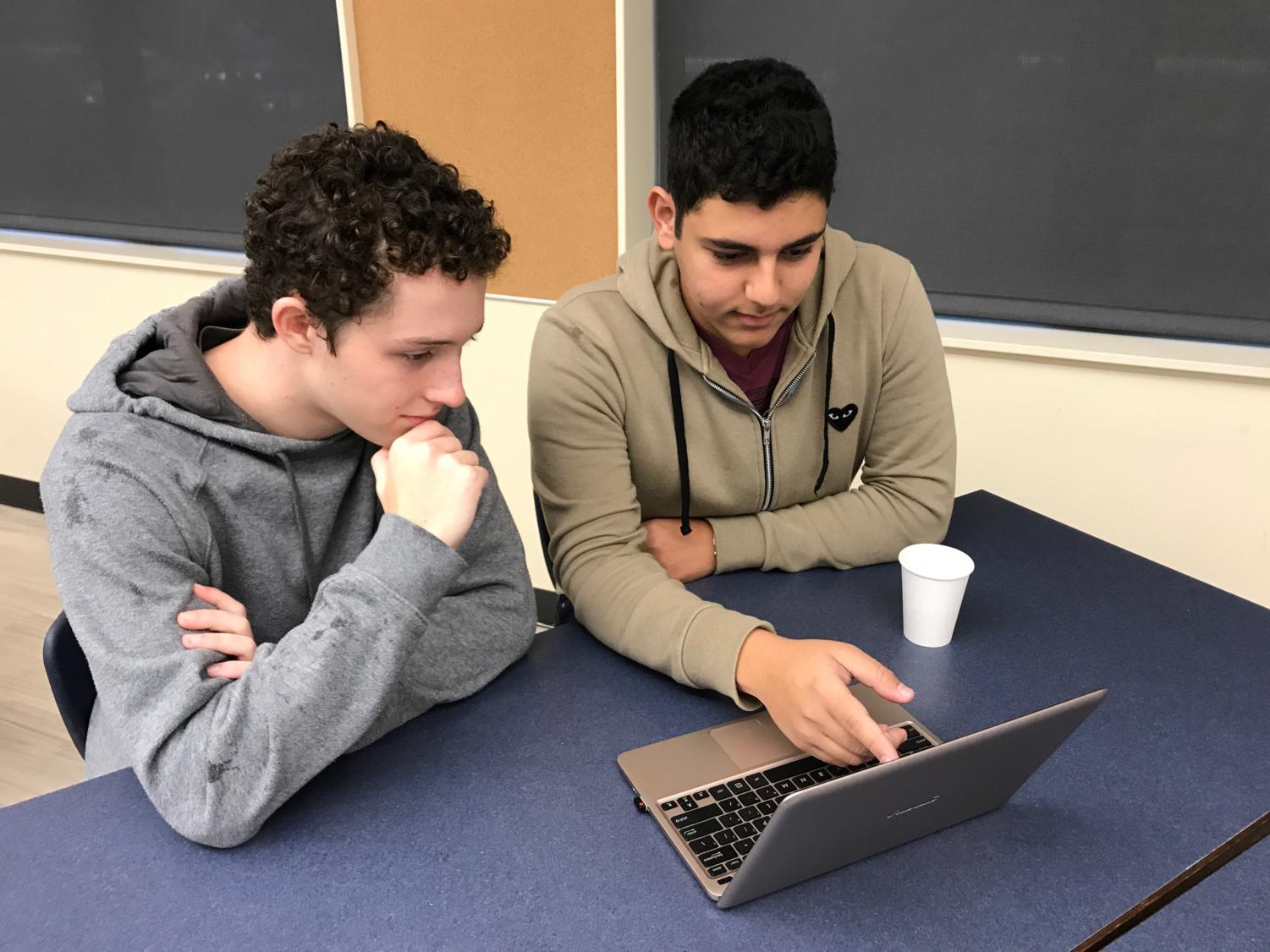 Seniors Jacob Werbner (left) and Amahn Enayati discuss a lesson plan for “Teen Tech Help,” the
program they run to teach senior citizens how to use technology.