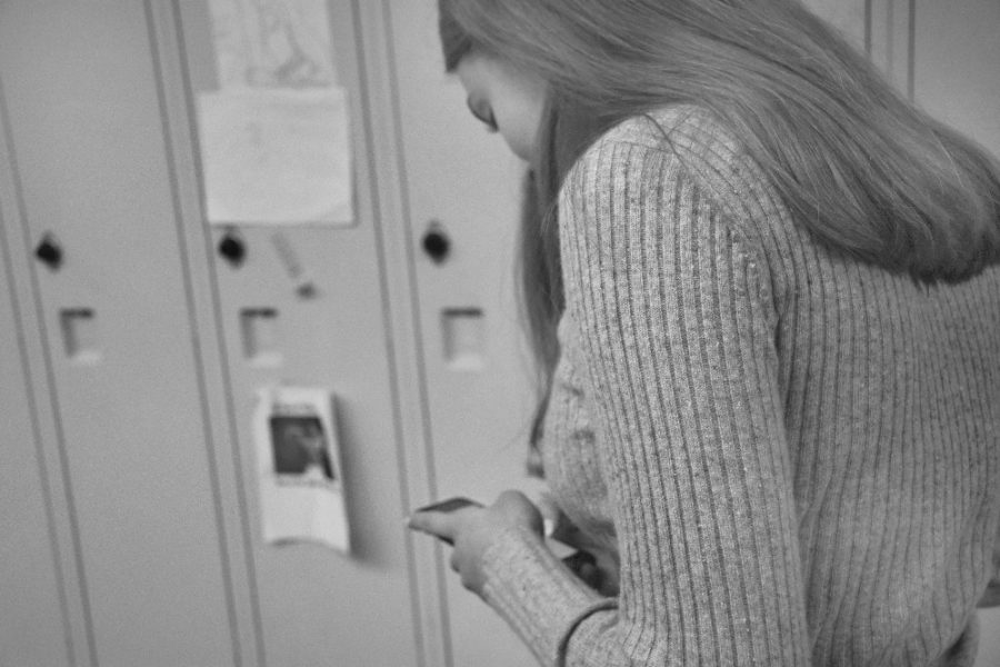 Senior Libby Lazzara uses her phone in a Lincoln hallway last year. Phone use among teens is hurting
personal relationships and increasing levels of anxiety.