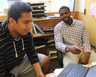 History teacher Ryan McCants (right) helps a student in 2015, when he came to Lincoln as attendance
monitor. Before this, he was a running back for the Oregon State Beavers.