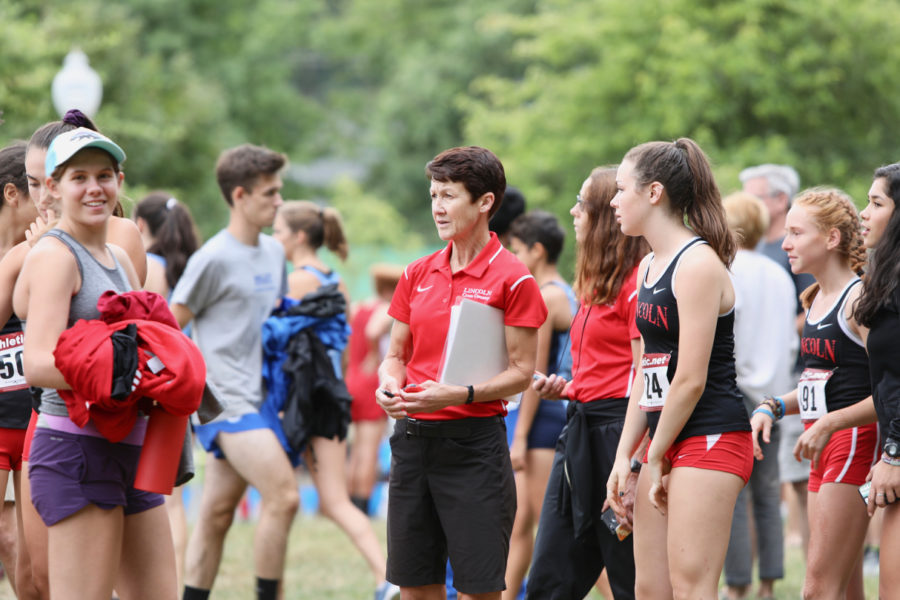 Parry speaks to former Lincoln student Ellie Kobak, left, and senior Mary Skakel, right, at Bill Chapman Invitational, Aug. 30, at Rood Bridge Park in Hillsboro.