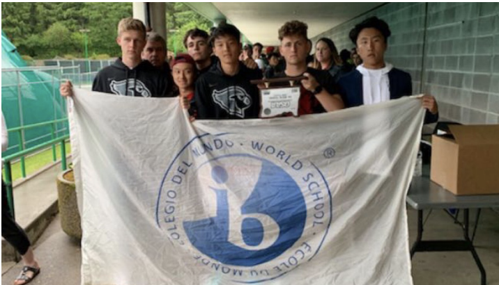 Lincoln+Varsity+Tennis+team+poses+with+an+International+Baccalaureate+flag+and+their+second+place%0AOSAA+trophy+upsidedown+expressing+their+anger+and+disappointment+with+the+organization.