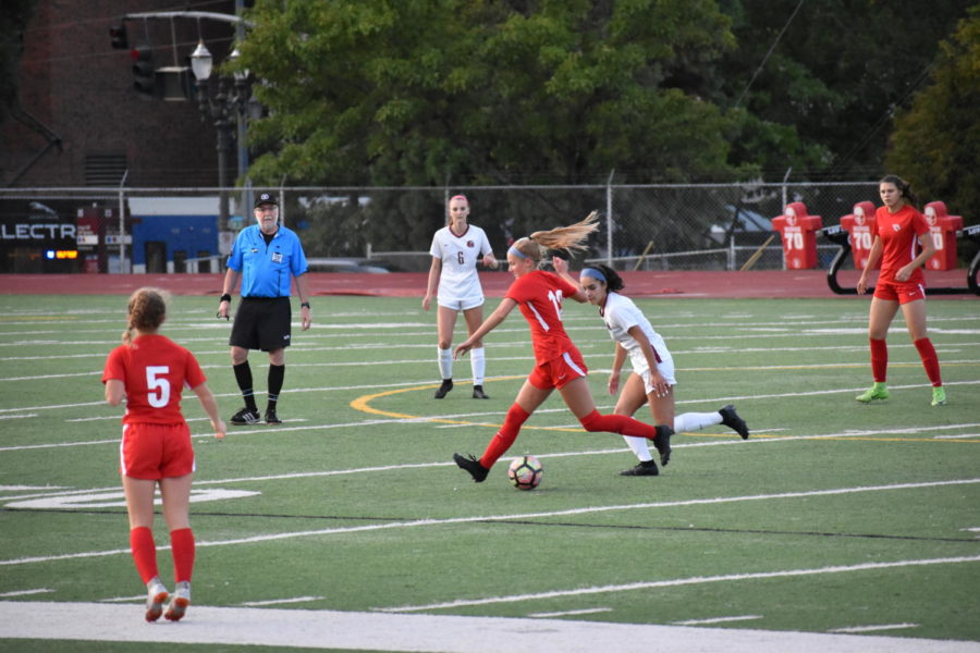 Junior Jolie Maycumber keeps the ball away from a defender during a varsity girls soccer home game against Glencoe on Sept 12. Lincoln won 9-0. Along with girls soccer, other fall sports are underway, and coaches and players are excited for the season to come.