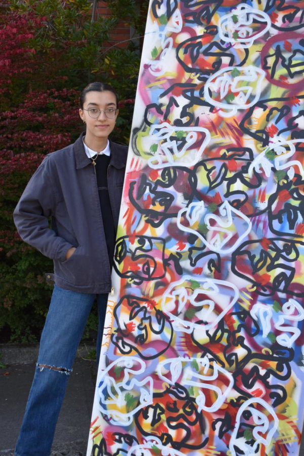 Photo of Tasneem Sarkez next to her artwork 