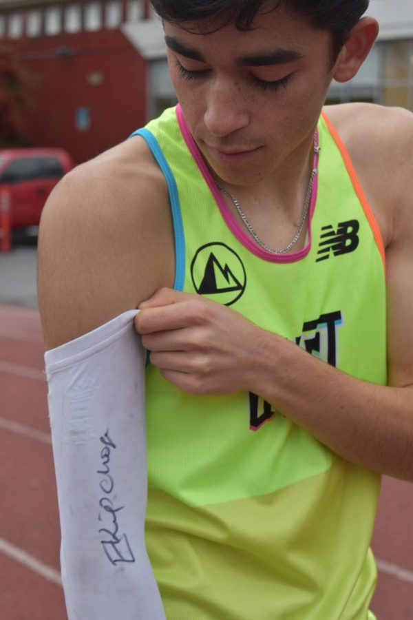 Althouse suits up by rolling up his signature arm sleeve, signed by marathon world record holder Eliud Kipchoge of Kenya.