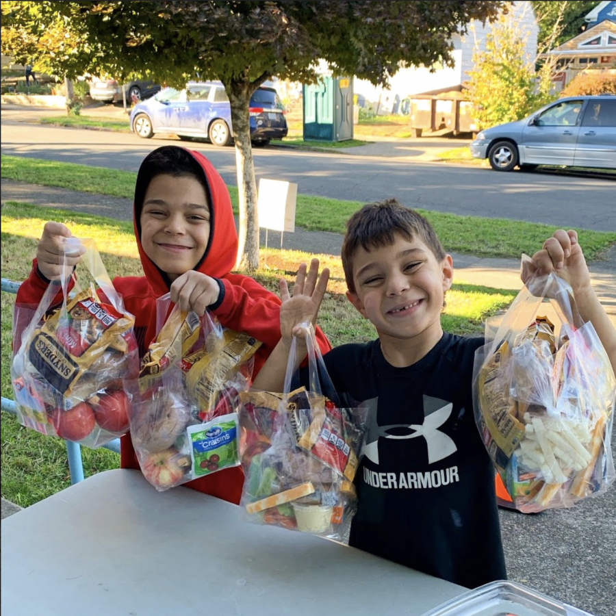 These+two+students+among+others+received+their+lunch+pack+for+the+week.+From+3+to+5+p.m.+on+Mondays%2C+Wednesdays+and+Fridays%2C+families+can+pick+up+meals.