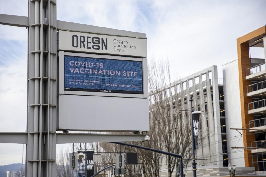 A sign outside the Oregon Convention Center designates it as a COVID vaccination site.