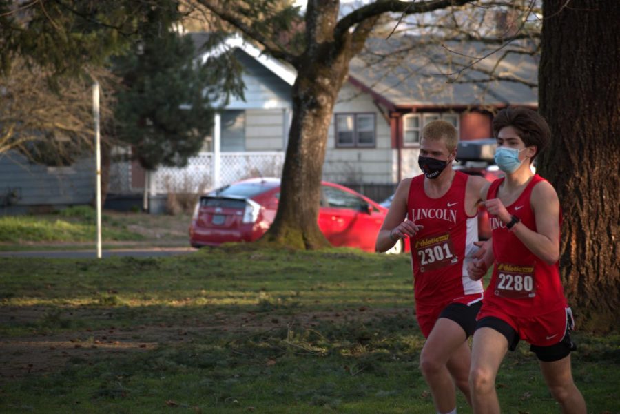 Junior Charlie Townes, left, and sophomore Trevor Dix, right, race in masks.