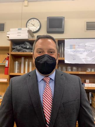  Admin practicum student and physics teacher Michael Schneller stands in a physics classroom. He agreed to teach one freshman physics class while he does his admin practicum.