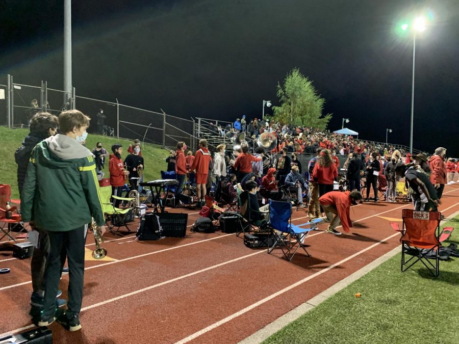 Members of the Lincoln band relax in between songs at homecoming game. The band programs at Lincoln have resumed in person performances this school year, including playing at football games such as this one.