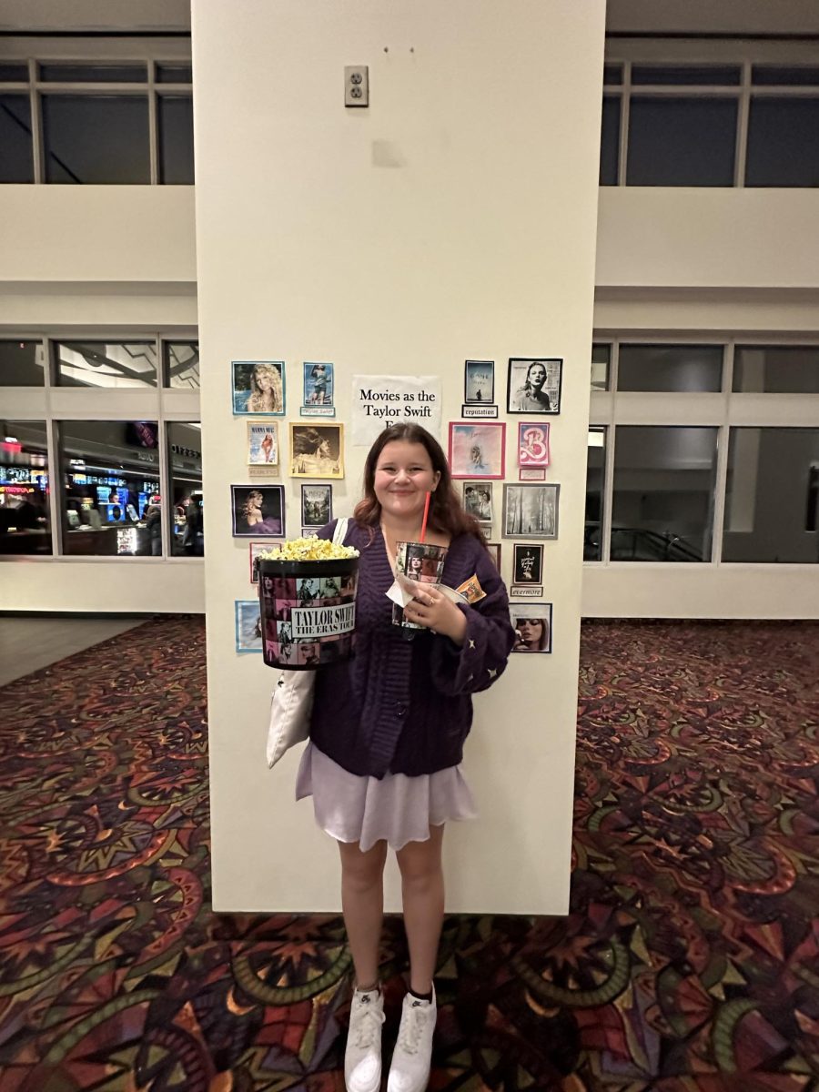 Reporter Lola Kovel with her collectible Taylor Swift popcorn bucket and cup at the theater on the opening night of Taylor Swift: The Eras Tour.
