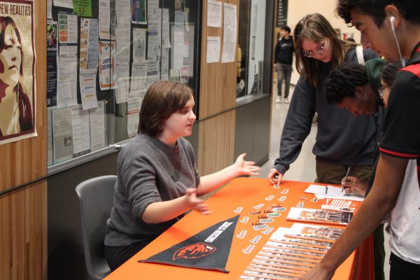 Oregon State University regional admissions officer Zoe Braun speaks with Lincoln seniors on what Oregon State has to offer. College representatives occupy tables by the main office during FLEX, lunch and after school.
