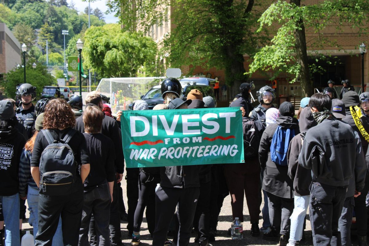 At a protest at Portland State University, a protester holds a sign with demands for the university to divest from companies that provide military aid to Israel. 