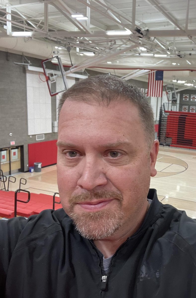 Lincoln’s new athletic director, Matt Wiles, stands at the top of the gymnasium bleachers. Wiles is impressed by Lincoln’s facilities and is excited to use them. 