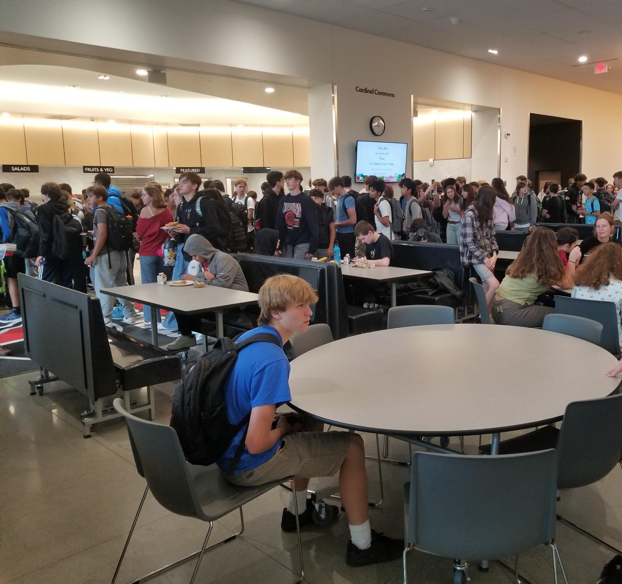 Students are waiting in line for lunch. Administrators say more students are staying on campus now that lunch is free.