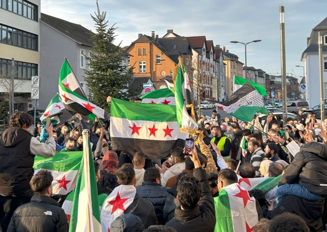 Syrians across the globe celebrated the fall of the Assad regime on December 8, 2024, such as in this image in Germany. Bashar al-Assad was the nation’s dictator for 24 years, preceded by his father Hafez al-Assad.   

Photo from Wikimedia Commons