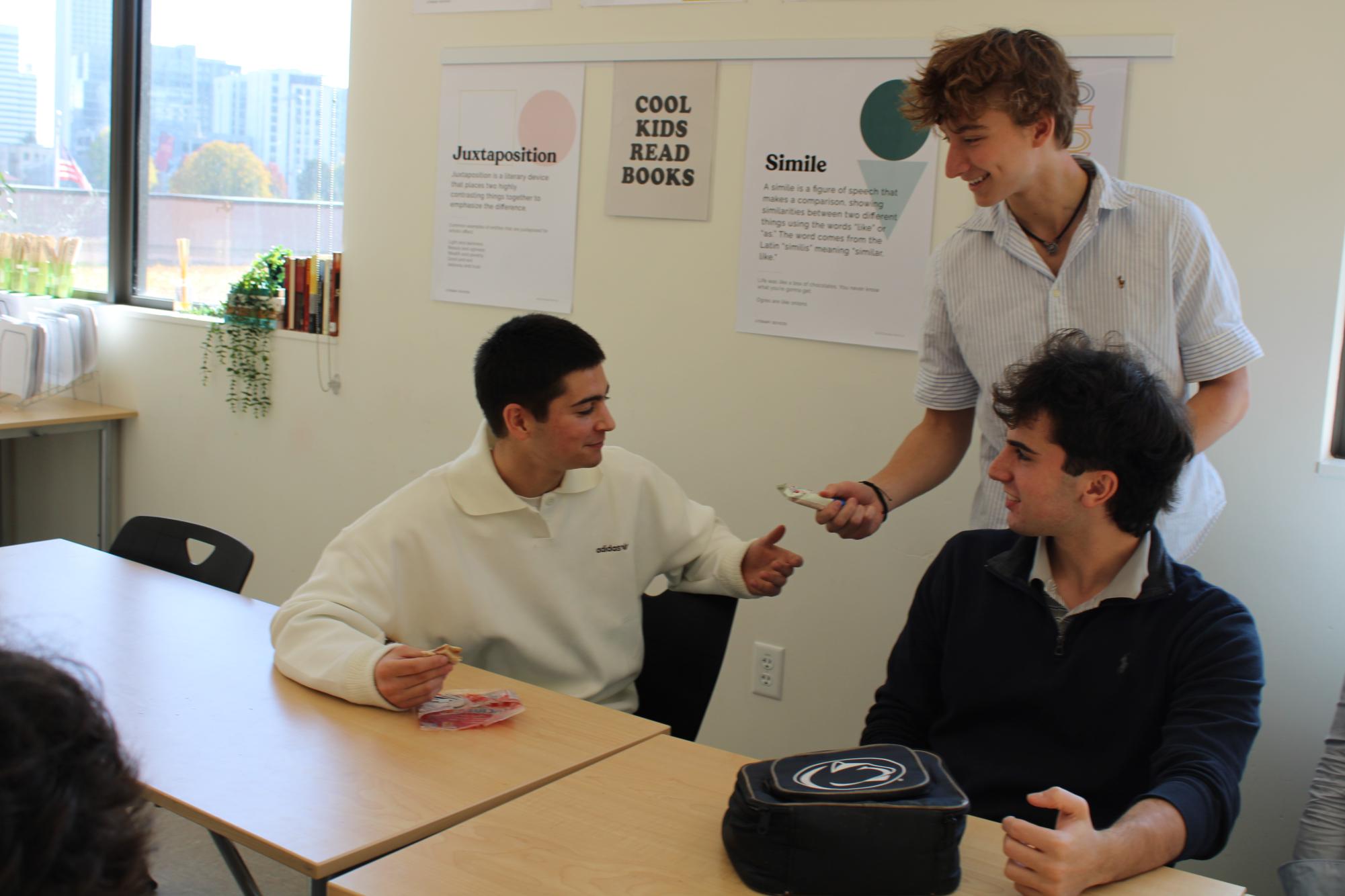 Senior Logan Ferrua (Top Right) gives students in Gather and Grub (Bottom left) a snack during a Gather and Grub meeting. By Eli Phanroy
